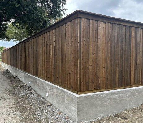 Concrete barrier wall with stained cedar privacy fence