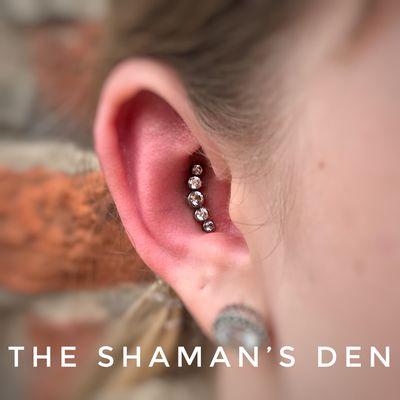 Conch piercing with an Anatometal 5 gem arc cluster by Daniel Kicinski.