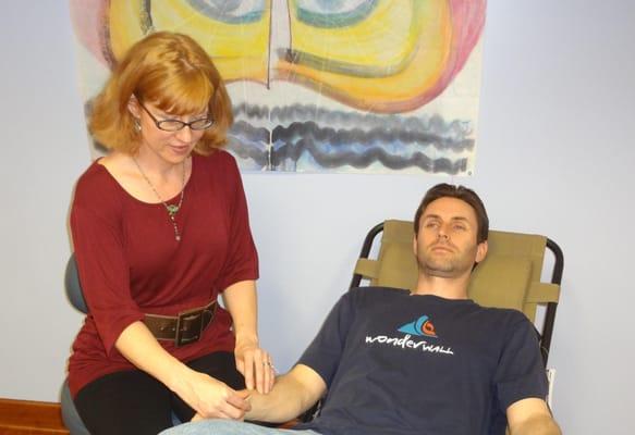 Kate doing acupuncture on a patient at a Community Acupuncture event at Still Point Yoga.