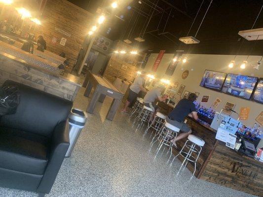 High counter seated bar for customers enjoy an adult beverage as they wait for their appointment.