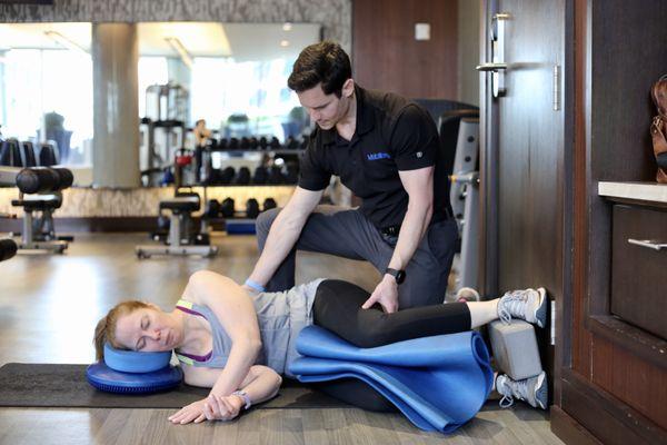 Owner Ryan Beauchesne working with a client to reposition her pelvis prior to exercise.