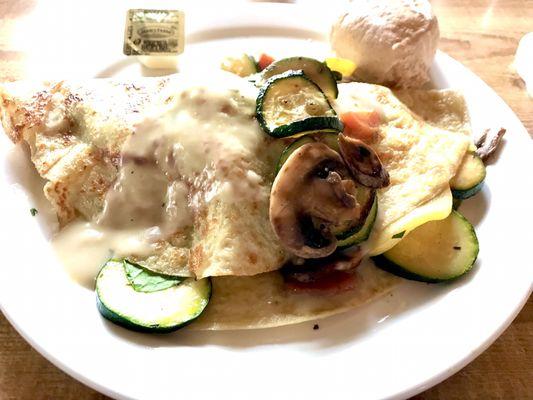 Vegetable crepe with a cream sauce and a roll. A filling but light meal.