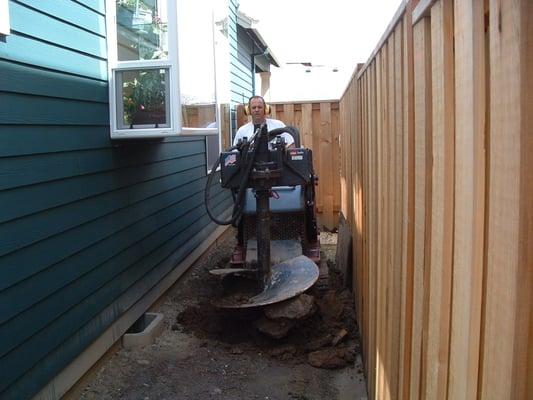 We can drill up to eight feet with this small machine. We were loosening up soil to remove for a walkway