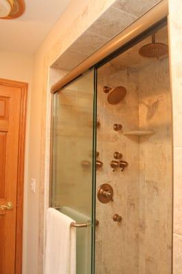 Another view of shower showing rain shower head. Each shower head has a separate control and top side sprays are separate also.