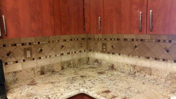 "Crazy Horse" granite countertops with a custom inlaid travertine backsplash and new cabinetry.