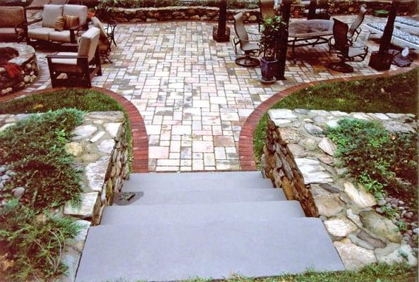 Outdoor living, backyard patio with stone wall and stone fire pit.