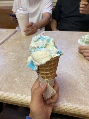 Two scoops of birthday cake in a waffle cone