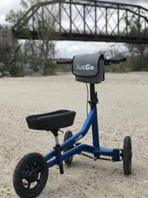 Blue JusGo Knee Scooter, also showing it's all terrain capabilities.  Go Anywhere!