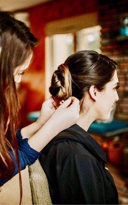 In action shot of Bridget Buscemi doing a low updo bun on a brides maid!