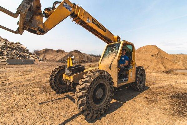 SITECO. Demolition Founder Dalton Crabtree sitting on telehander at a large demolition site