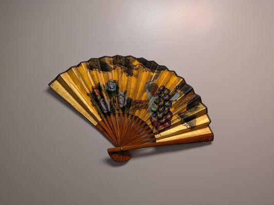 Ornamental gold fan hanging on the wall