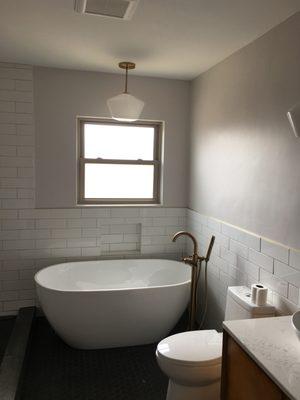 A freestanding tub and filler were installed where the previous tub/shower combo was.