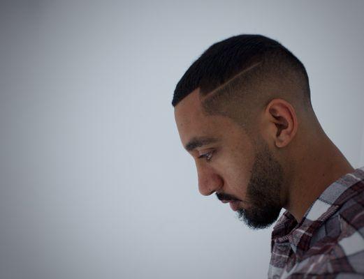 Mid bald fade with part and beard line up, done by Angel