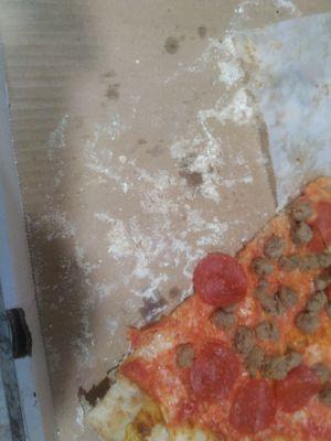 Excess flour left I nthe bottom of the box after taking pizza out.