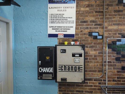 A change machine at the rear of the laundromat.