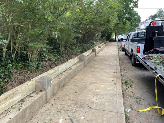 New wooden retaining wall installation.