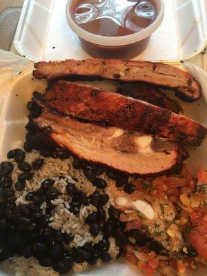 Half rack of ribs with the sauce on the side; rice and beans