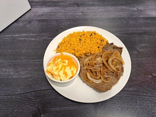 Steak ,and onions served with a side of rice and beans