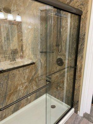 Tub to shower conversion in Juparana Granite with oil rubbed bronze fixtures and framed glass doors.