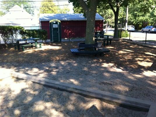 Portable toilet, picnic tables, sandbox