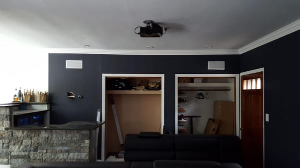 In this photo you can see the rear view of the projector and surround sound speakers in wall...