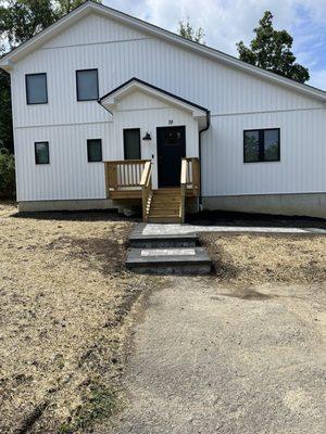 Front walkway with pavers and steps. Graded yard with seed and hay for new lawn.