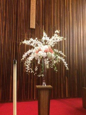 orchids, hydrangeas and roses in lovely church arrangement.