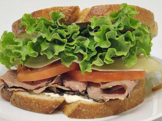 Roast Beef Sandwich - Sliced roast beef, caramelized onions, provolone cheese, tomato slices, green lettuce. Horseradish Aiolion on sourdoug