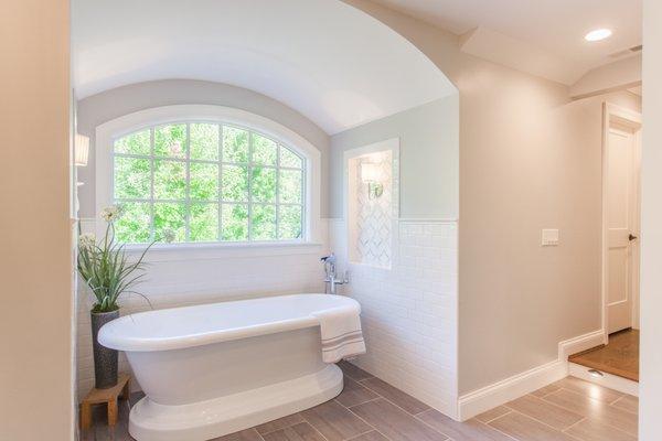 Dreamy soaking tub with barrel ceiling, flanked by sconce niches.