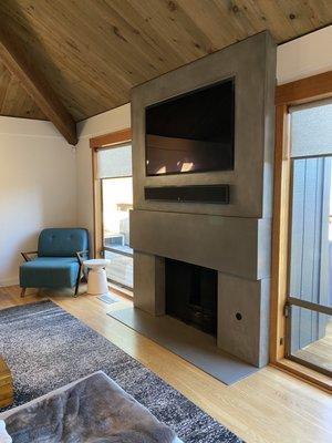 (Modern concrete fireplace surround with recessed TV opening)