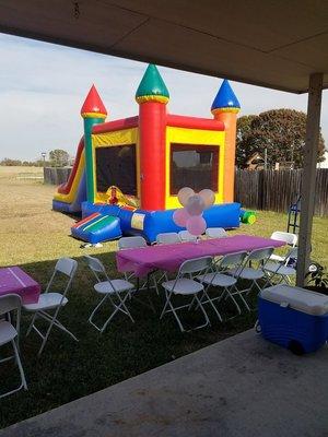 Castle moonwalk with tables and chairs.