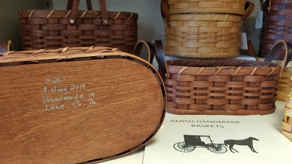 Baskets are signed by the Amish basket weaver who made them.