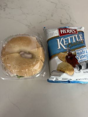 Turkey sandwich on plain bagel and a bag of salt and vinegar chips