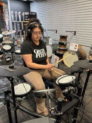 Emily trying out the electric drum kits. Julie A