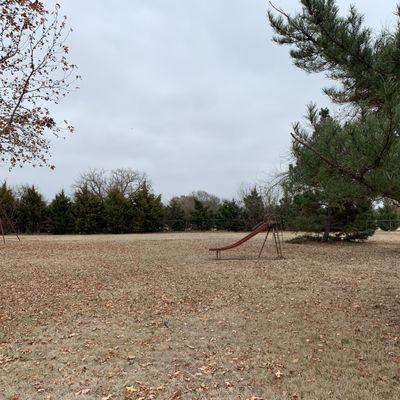 Old slide in the middle of the grassy fields.