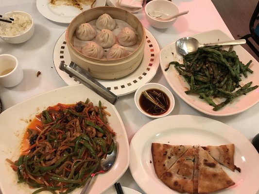 Soup dumplings, shredded pork with garlic sauce, dry sautéed string beans, and scallion pancake