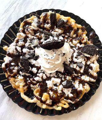 Funnel cake with chocolate sauce and Oreo crumbles