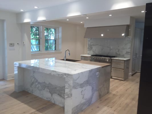 This kitchen contains a custom waterfall marble island with ultra wide plank white oak floors and Siematic cabinets.