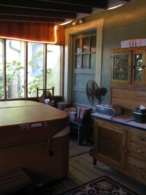 Enclosed back porch with jacuzzi hot tub.