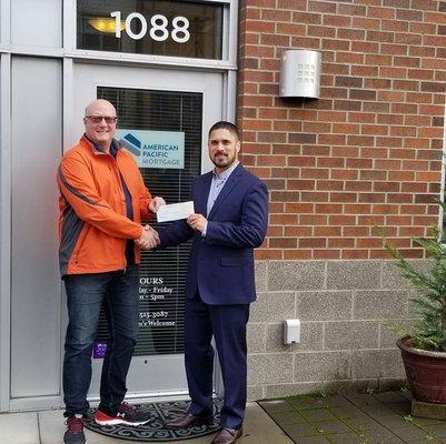 Chris Barry from APM Hillsboro giving donation to Jeremy Toeys of OPEN DOOR.  #CreatingExperincesthatMatter #APMCares