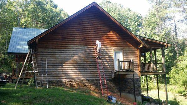 Restoration of Log home exterior. Applying stain after striping the old finish off the home.