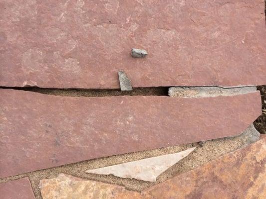 More cracked mortar and gaps between flagstones where sand has fallen through