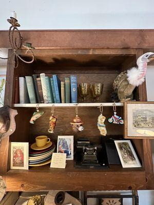 Travel shelves at Susan's Storeroom with Smoky The Bear ornament, books, etc.