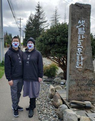 My husband and I, wearing Korean Flag Face Masks, at the Entrance to the parking lot