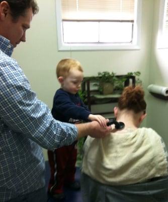 Dr Cole doing ultrasound and muscle stimulation with the assistance of his patient's son.