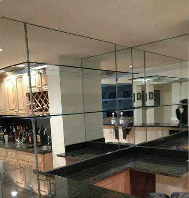 Mirrored walls with glass shelves are a beautiful addition to any bar area.