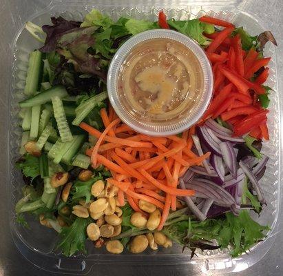 Thai Salad of mixed greens, peppers, edamame, red onions, cucumbers, shredded carrots and peanuts. Thai Chili Vinaigrette. GF, V, Vegan