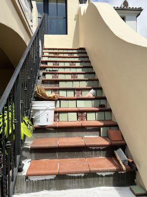 My staircase in process with stair treads, corners and custom deco from California Pottery & Tile.