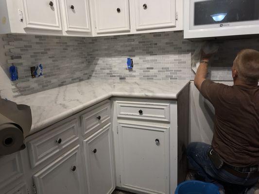 One of my guys grouting the marble backsplash after we installed the marble countertops