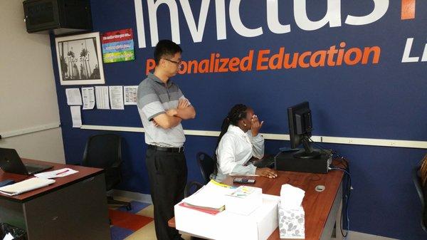 Invictus High School teacher watches over a student as she completes her math assignment.